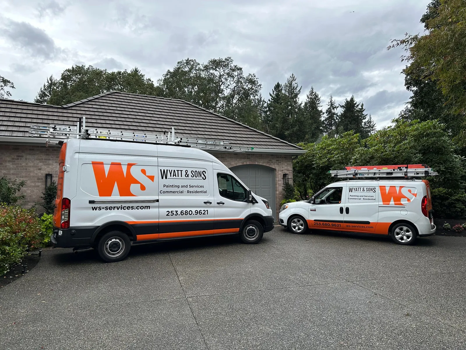 Wyatt & Sons company vans parked outside a job site